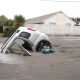 A car in a hole caused by liquefaction following the Christchurch earthquake