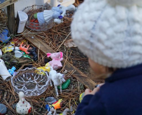 A young girl looks down onto a farmland made with toys